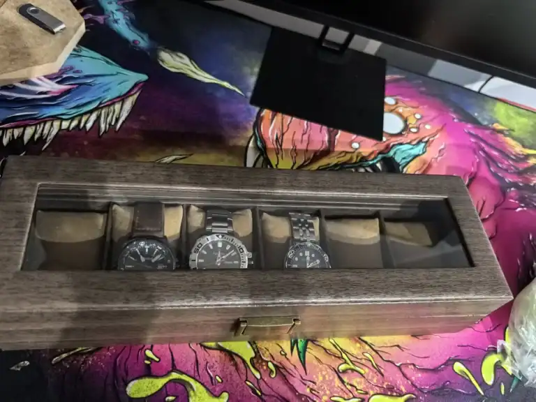 Boîte en bois pour montres avec trois montres à bracelet.